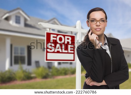 Attractive Mixed Race Woman in Front of House and For Sale Real Estate Sign.