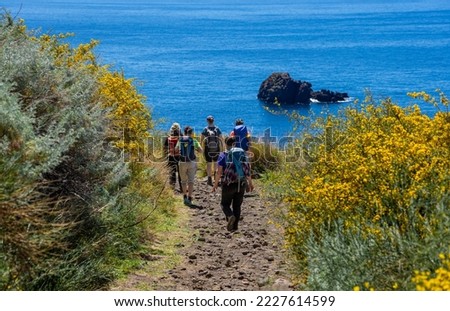 Sicily in spring: coastal hike on the island of Lipari - hiking group in the west with a view of the neighboring island of Salina Royalty-Free Stock Photo #2227614599