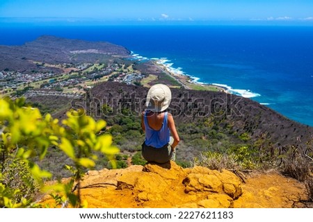 girl in a hat enjoys the oahu panorama from the top of the famous koko crater railway trailhead, oahu, hawaii, hiking in hawaii, holiday in hawaii Royalty-Free Stock Photo #2227621183