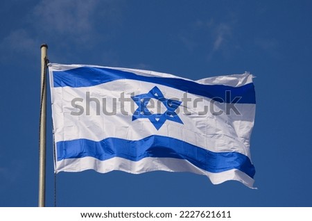 Flags of Israel in the wind. Beautiful blue sky. Star of David, blue and white flag of the State of Israel