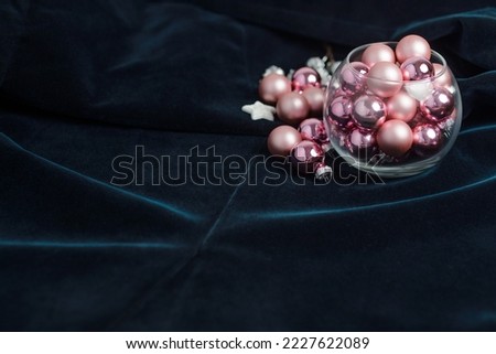 Christmas arrangement of pink Christmas tree balls and glass vase, silver star on dark background. Preparation for the holidays. High quality photo
