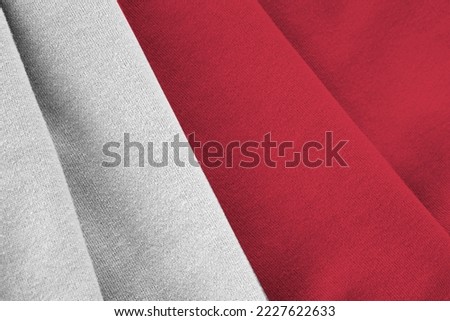 Malta flag with big folds waving close up under the studio light indoors. The official symbols and colors in fabric banner