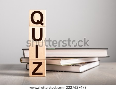 Quiz letters on wood blocks and books for school education. Quizz, test for knowledge and background. High quality photo