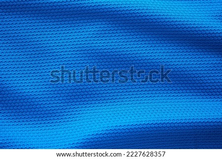 Blue football jersey clothing fabric texture sports wear background, close up top view Royalty-Free Stock Photo #2227628357