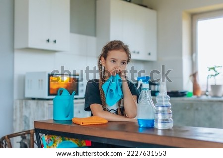 Outraged angry child does not want to clean the house. Annoyed resentful little cute girl is too lazy to do house cleaning and does not want to do homework. Tired girl is sad after cleaning. Royalty-Free Stock Photo #2227631553