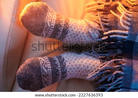 Feet of unrecognizable woman in socks by the Christmas fireplace