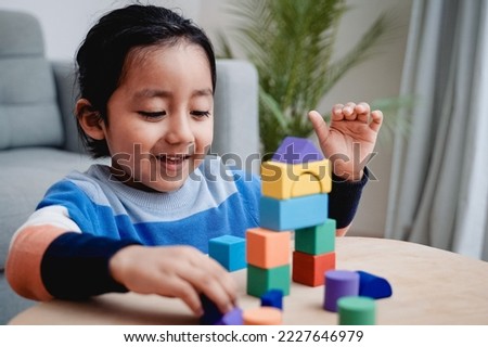 Happy Latin american kid having fun playing with toy bricks at home - Focus on toddler face. Royalty-Free Stock Photo #2227646979