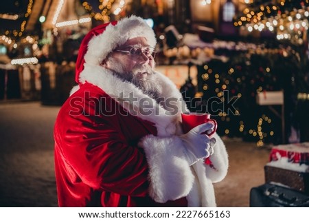 Photo of cheerful bearded old man wear comfort warm coat hat hand hold mug tasty hot chocolate enjoying frosty snowy weather outside