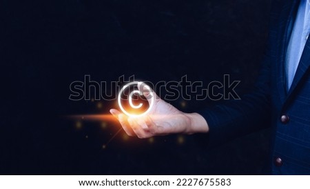 Businessman holding Copyright icon, patents and intellectual property protection law and rights. with symbol of the copyright.copyright symbol from the author. Royalty-Free Stock Photo #2227675583