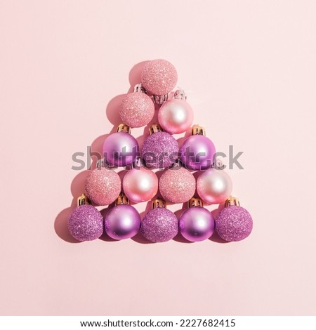 Pink christmas bubbles on pink background. Flat lay. Minimal New Year and Christmas concept idea.