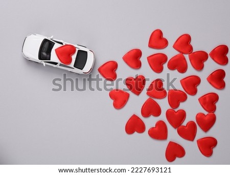Toy car with hearts on gray background. Love, romance, valentine's day, February 14 concept