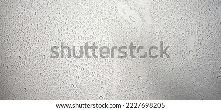 Photo of the texture of a chrome-plated iron surface in raindrops. Precipitation on the metal surface. Wet background of silver color.
