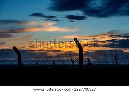sunset and border barbed wire