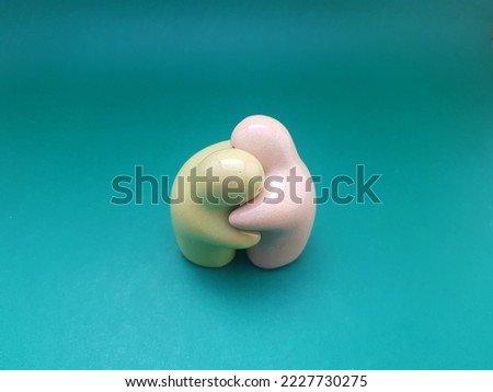 Interior decoration made of ceramic with hugging character on a green background