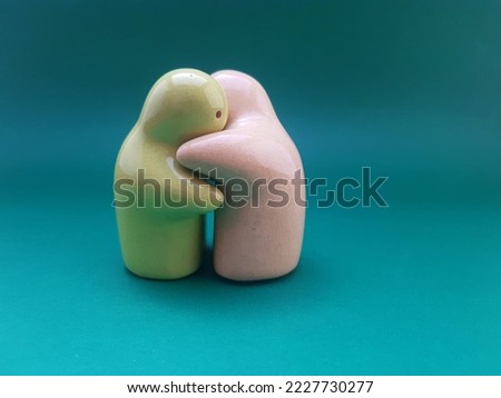 Interior decoration made of ceramic with hugging character on a green background