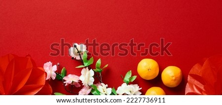 Happy Chinese New Year 2023 concept. Red lanterns decorations, blossom flowers, tangerines on red background.