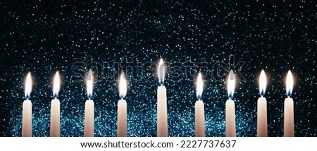 Hanukkah candles. Traditional candelabrum with burning candles on black background. Celebrating a religious Jewish holiday. Banner format