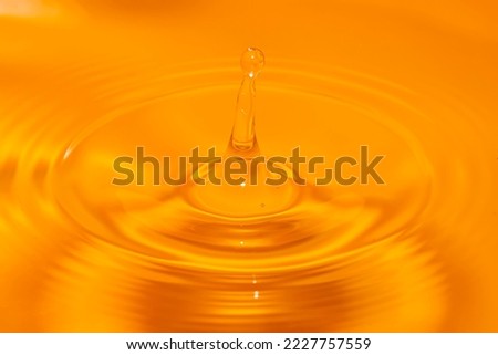 Photo of circles on the water from a fallen drop of water. Yellow, golden background. High quality photo
