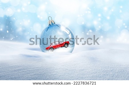 Transparent glass Christmas ball in the snow