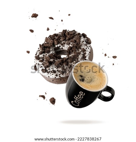 White chocolate glazed donut with dark cookies crumbs and black cup espresso coffee flying. Sweet doughnut and cup coffee falling isolated on white background