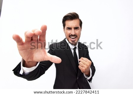 Portrait of a man in an expensive business suit close-up wide-angle lens pulling his hands into the camera with his mouth open screams against a white background, copy location Royalty-Free Stock Photo #2227842411