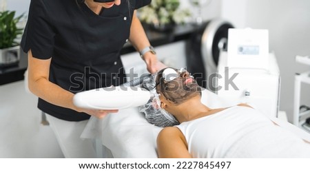 woman lying on a table and getting laser complexion cleaning at the spa center, body care and treatment concept. High quality photo