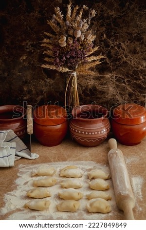 Cooking dumplings in the kitchen (retro and ethno style) Royalty-Free Stock Photo #2227849849
