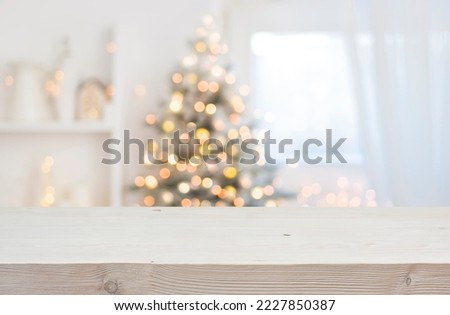 Wooden table in front of abstract blurred Christmas decorations background