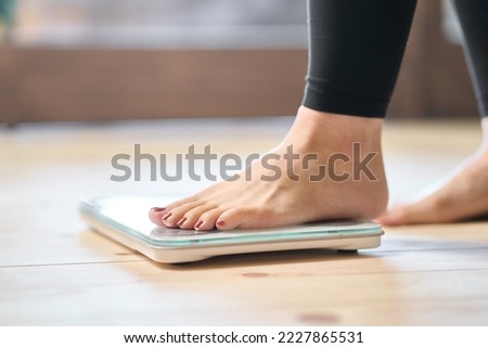 Feet of an Asian woman on a weight scale Royalty-Free Stock Photo #2227865531