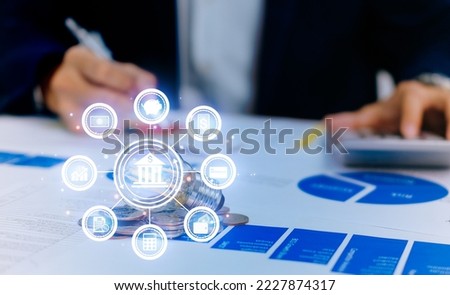 Business man hand holding lightbulb with using calculator to calculate and money stack. idea saving energy and accounting finance in office concept. Financial statistics, infographics papers.