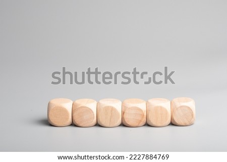 Empty wooden dice stacked on gray background