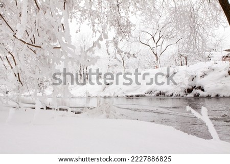 Snow-covered landscape of open spaces near the river. Snowy weather