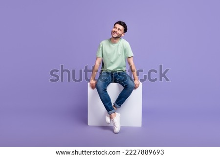 Full size photo of handsome young man sitting white podium look empty space dressed stylish gray outfit isolated on purple color background Royalty-Free Stock Photo #2227889693