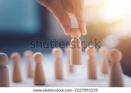 HR manager (human resources) or Employer hand choose takes person wooden doll. Leader stands out from crowd. Looking for good worker. HR, HRM, HRD concepts.