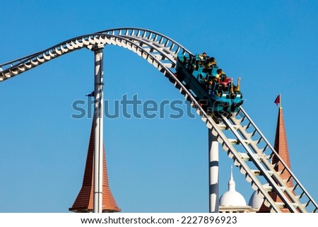 extreme rollercoaster at speed against the background of the blue sky and the castle. attractions
