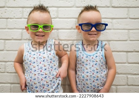 Young viewers of a home 3D cinema. Funny pictures of boys watching cartoons or movies wearing colorful 3d glasses.