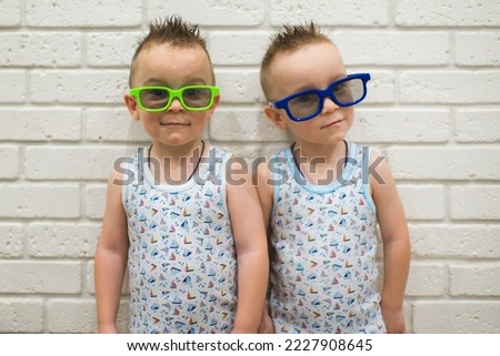 Young viewers of a home 3D cinema. Funny pictures of boys watching cartoons or movies wearing colorful 3d glasses.