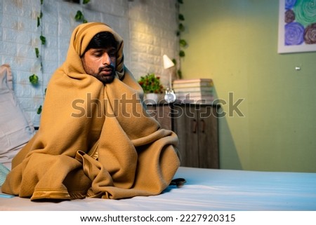 Shivering young man woke at night due to freezing cold at night on bedroom during winter - concept of sick, fever and unwell. Royalty-Free Stock Photo #2227920315