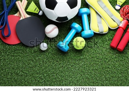 Set of different colorful sports equipment on green grass, flat lay. Space for text Royalty-Free Stock Photo #2227923321