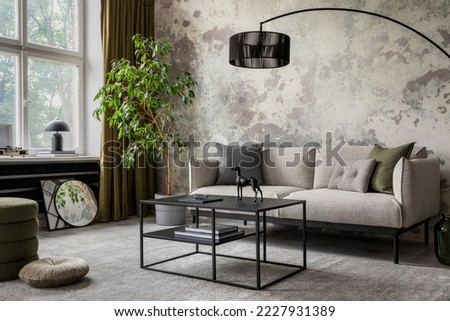 Industrial and loft living room interior with concrete wall, gray sofa, modern armchair, simple black coffee table, green pillows, curtain, books and personal accessories. Home decor. Template.  Royalty-Free Stock Photo #2227931389