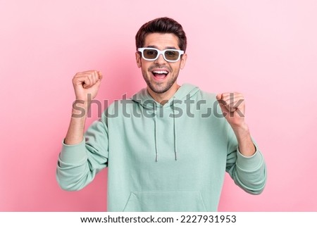 Photo of astonished satisfied person raise fists celebrate shout yes isolated on pink color background