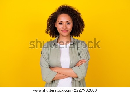 Photo of cute young woman wavy hair crossed arms confident entrepreneur dressed stylish khaki look isolated on yellow color background