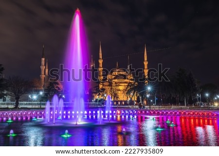 Colorful fountain shot with a long exposure with a blue mosque with six minarets at the background in Istanbul, Turkey.