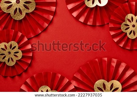 Frame of red paper fans with gold flowers on red background. Happy Chinese New Year 2023 concept. Royalty-Free Stock Photo #2227937035