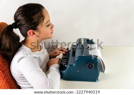 A girl who is blind types on a braille machine. braille keyboard.