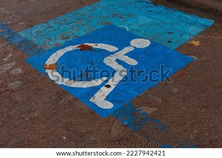 Close-up of a blue disabled parking sign on a city street.