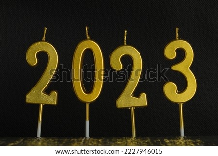 Holiday background Happy New Year 2023. Numbers of the year 2023 made by gold candles. celebrating New Year's holiday.