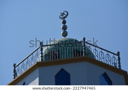 Green glided  dome and crescent moon Muslim mosque against the background of the beautiful blue sky in chittagong Bangladesh