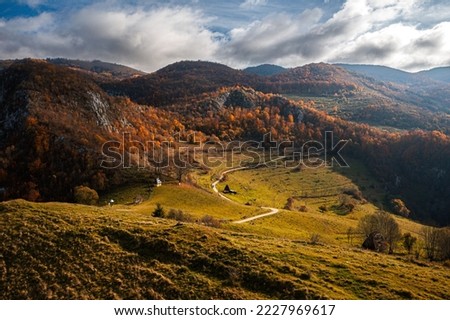 Visit Transylvania, Romania. Aerial view of Dumesti village with traditional old houses at the bottom of Apuseni Mountains in autumn color. Royalty-Free Stock Photo #2227969617