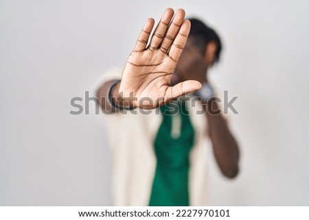 African man with dreadlocks standing over isolated background covering eyes with hands and doing stop gesture with sad and fear expression. embarrassed and negative concept. 